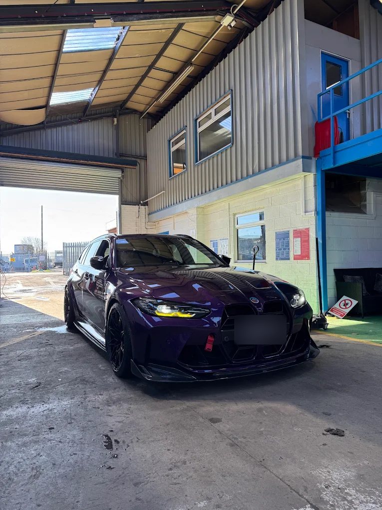 Purple BMW M3 Touring at the entrance of the Liam's Tyres garage