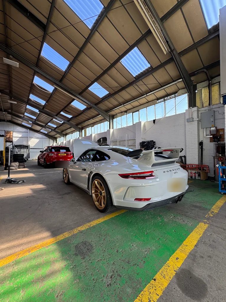White Porsche 911 GT3 with gold wheels inside the Liam's Tyres workshop in Gateshead
